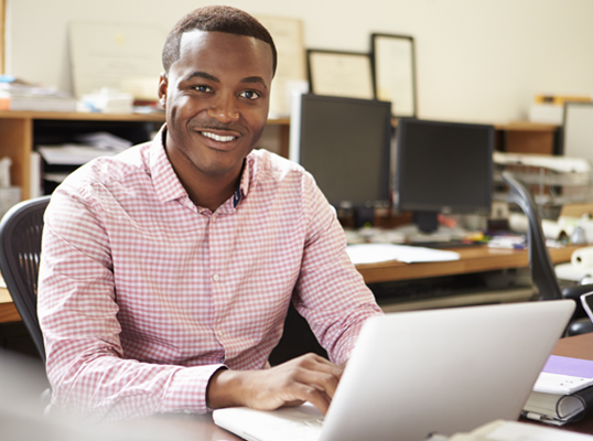 smiling man working on his laptop